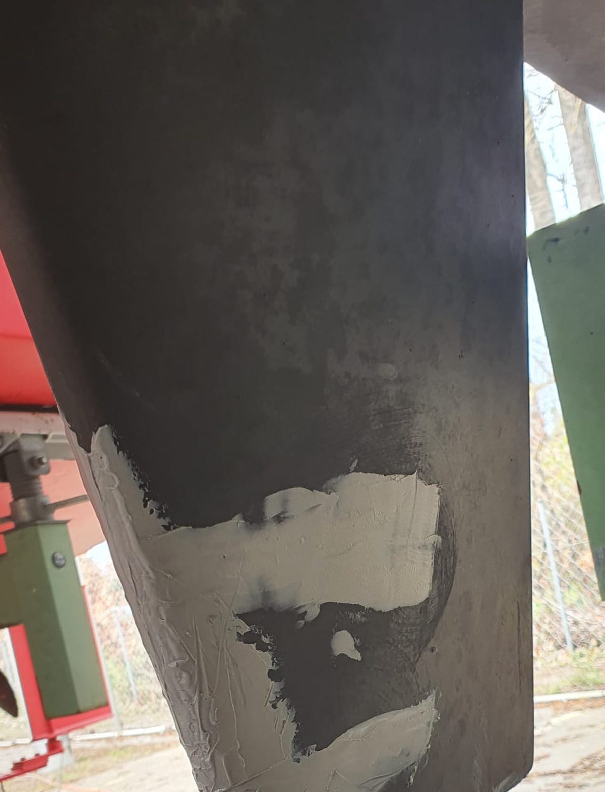 Detail eines Bootsrumpfes mit gespachtelter Reparaturstelle nach einem Aufsetzer, vor dem Neuaufbau des Antifoulings