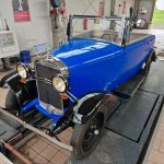 Koenigsblauer Opel Adam Cabriolet von 1934 mit schwarzen Kotfluegeln, Cabrio offen, steht auf einem HU-Pruefstand