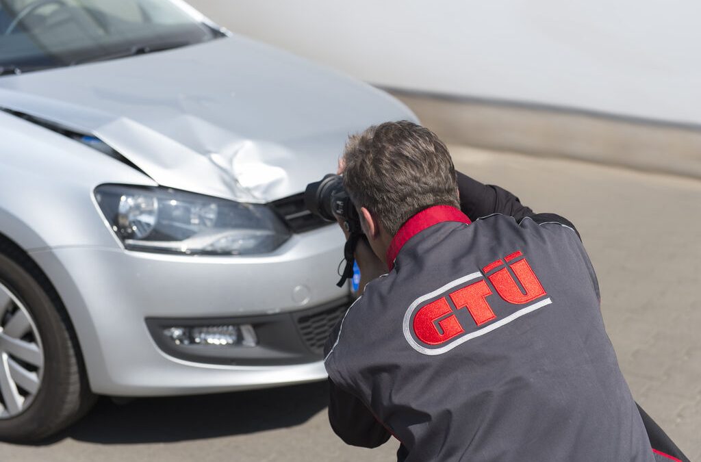 GTUe-Sachverstaendiger fotografiert einen Schaden am Fahrzeug mit Spiegelreflexkamera